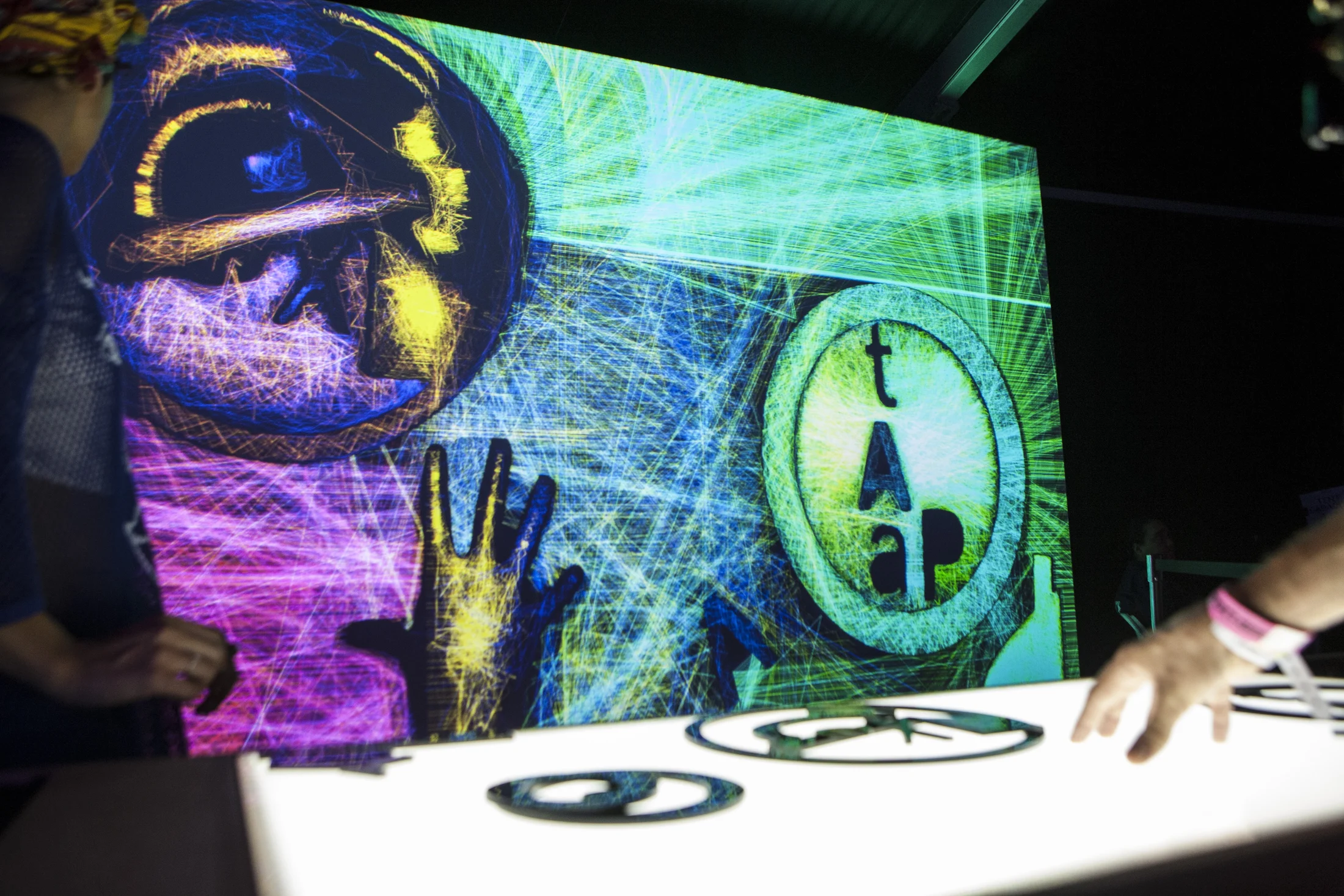 A visitor facing a large colorful projection