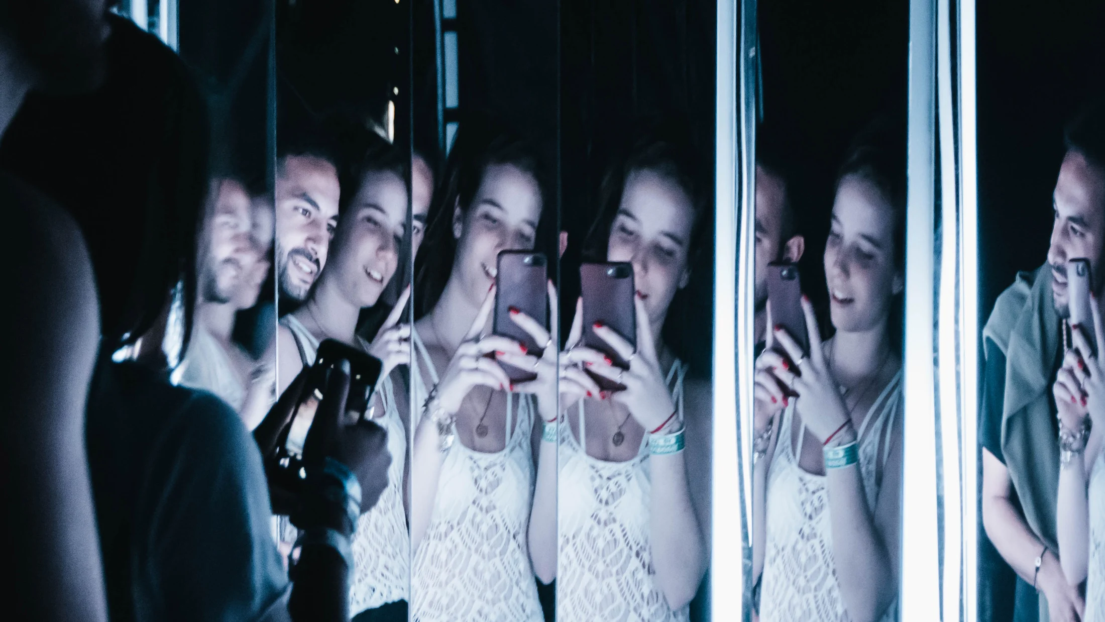 Visitors among a field of illuminated vertical tubes