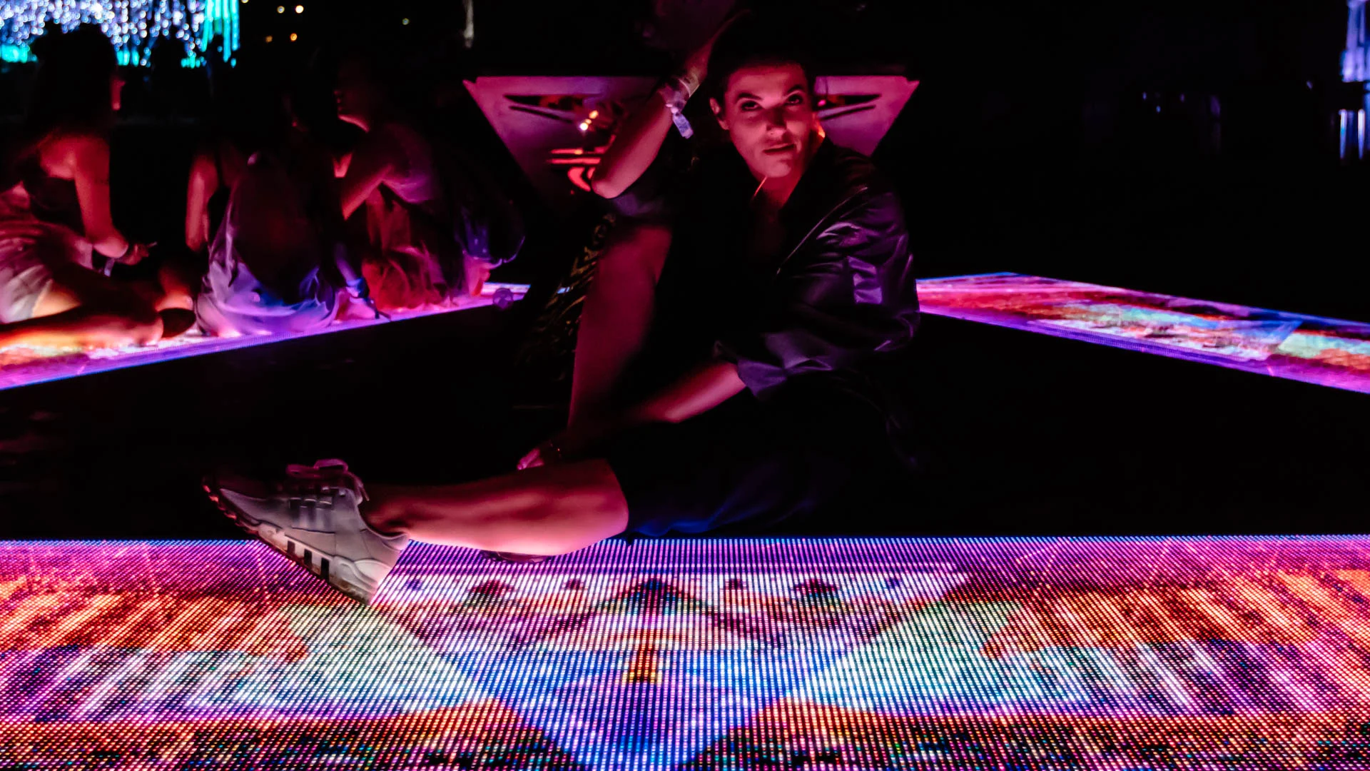 A visitor leaning over an interactive illuminated surface
