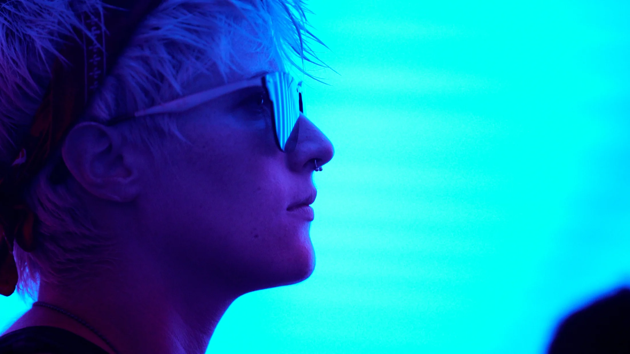 A visitor in profile against saturated blue and pink light